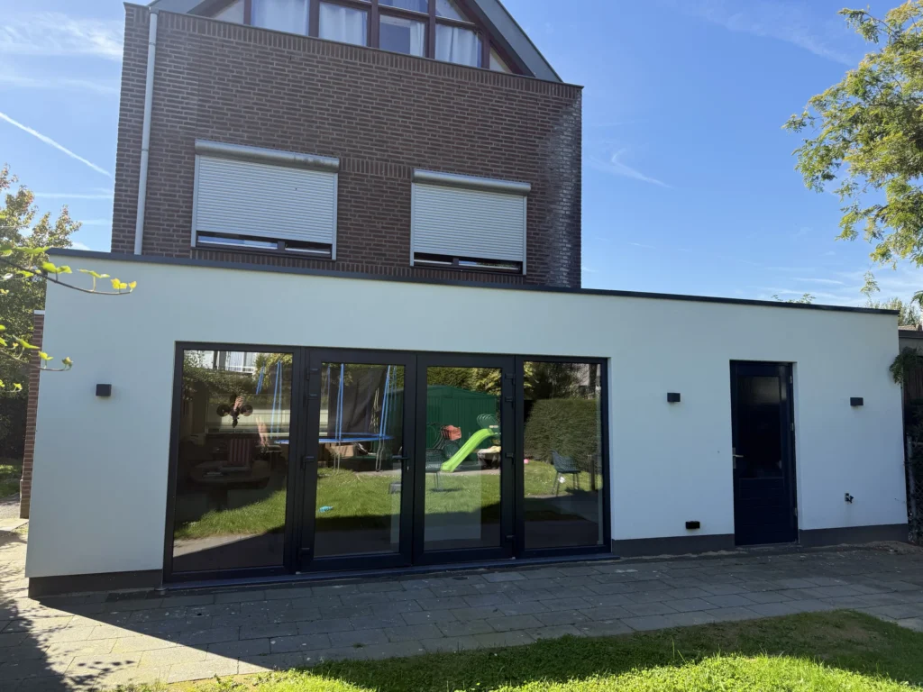 Achtergevel met de nieuwe aanbouw en grote glazen pui in Hoogveld, Sittard