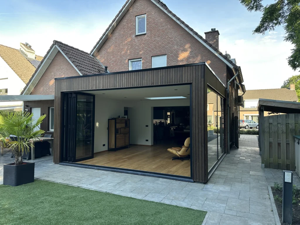 Zitkamer in de aanbouw met doorgelegde parketvloer en open harmonicapui