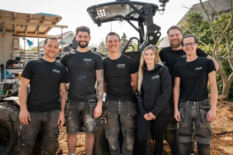 Het team van Plum Projects voor de graver van Plum Projects op de bouwplaats