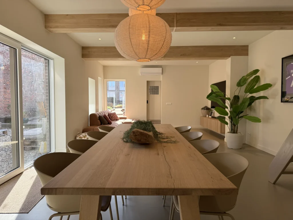 Gerenoveerde woonkamer met eikenhouten balken en naadloze gietvloer in Nieuwstadt
